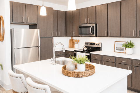 A kitchen with a white table and brown cabinets.