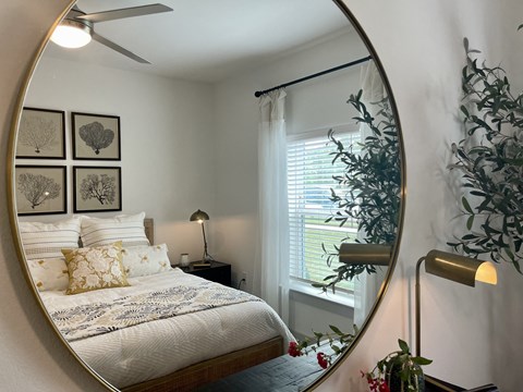 a bedroom with a bed and a mirror