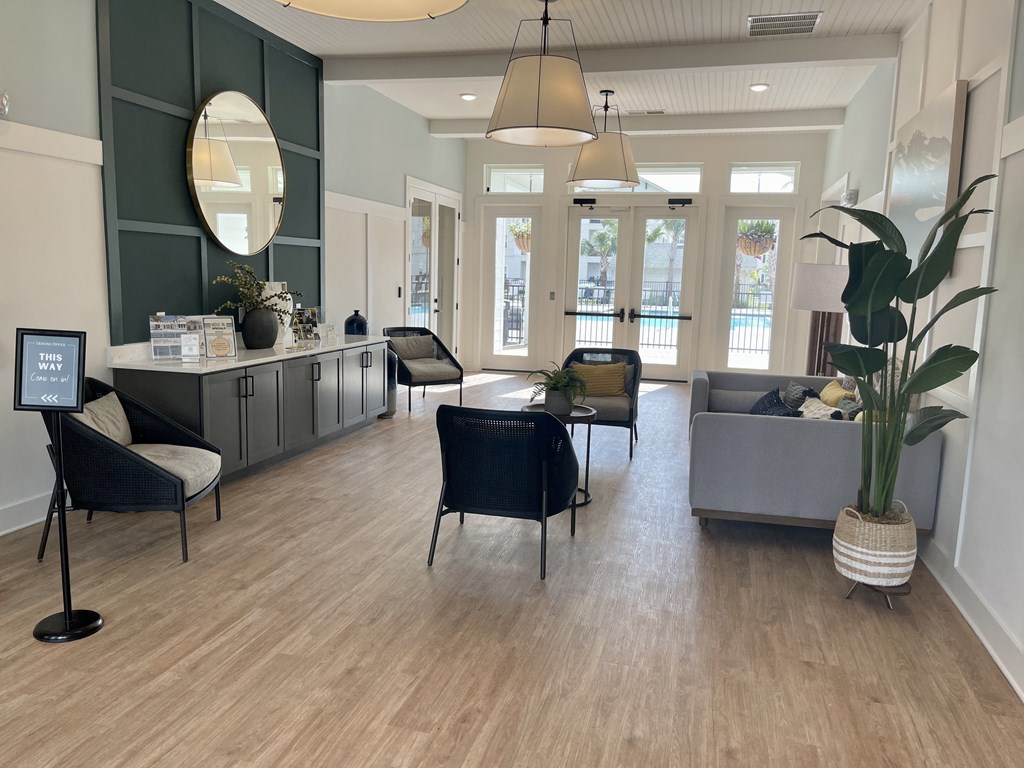 a living room with hardwood floors and gray furniture