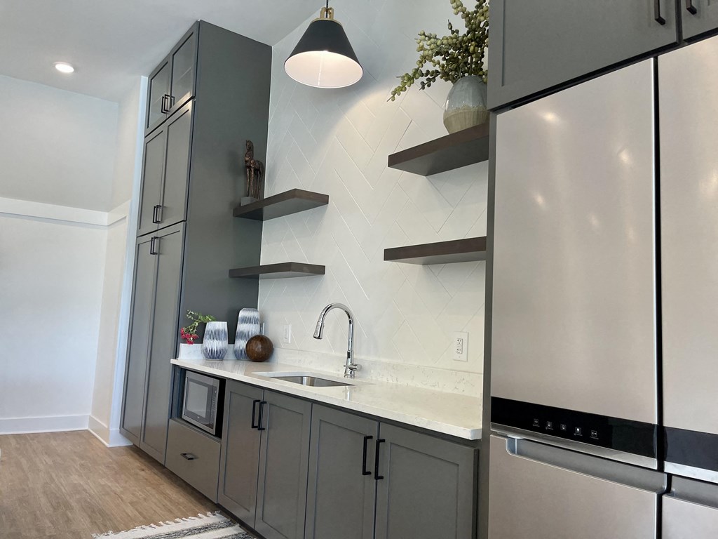 a kitchen with gray cabinets and white countertops