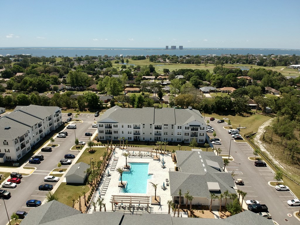 an aerial view of the resort style pool and parking lot