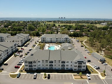 an aerial view of a large building with a pool in the middle of a parking lot