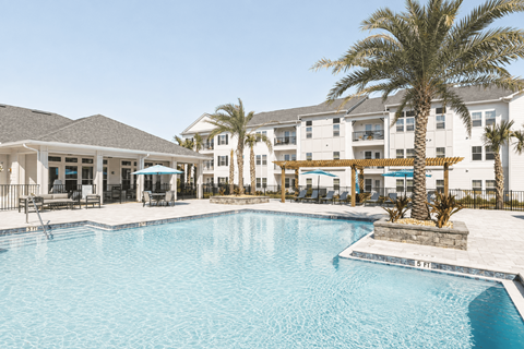 A large swimming pool in front of a resort.