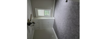 A room with a window and a ceiling fan.
