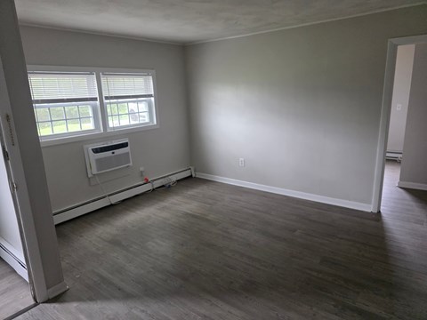 A room with a window and a wall-mounted air conditioner unit.