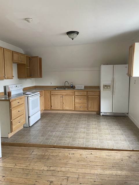 A kitchen with wooden cabinets and a white refrigerator.