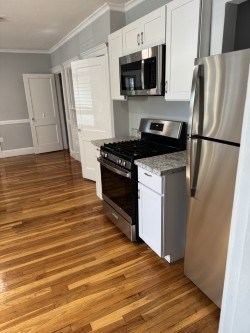 A kitchen with a stainless steel refrigerator, microwave, and dishwasher.