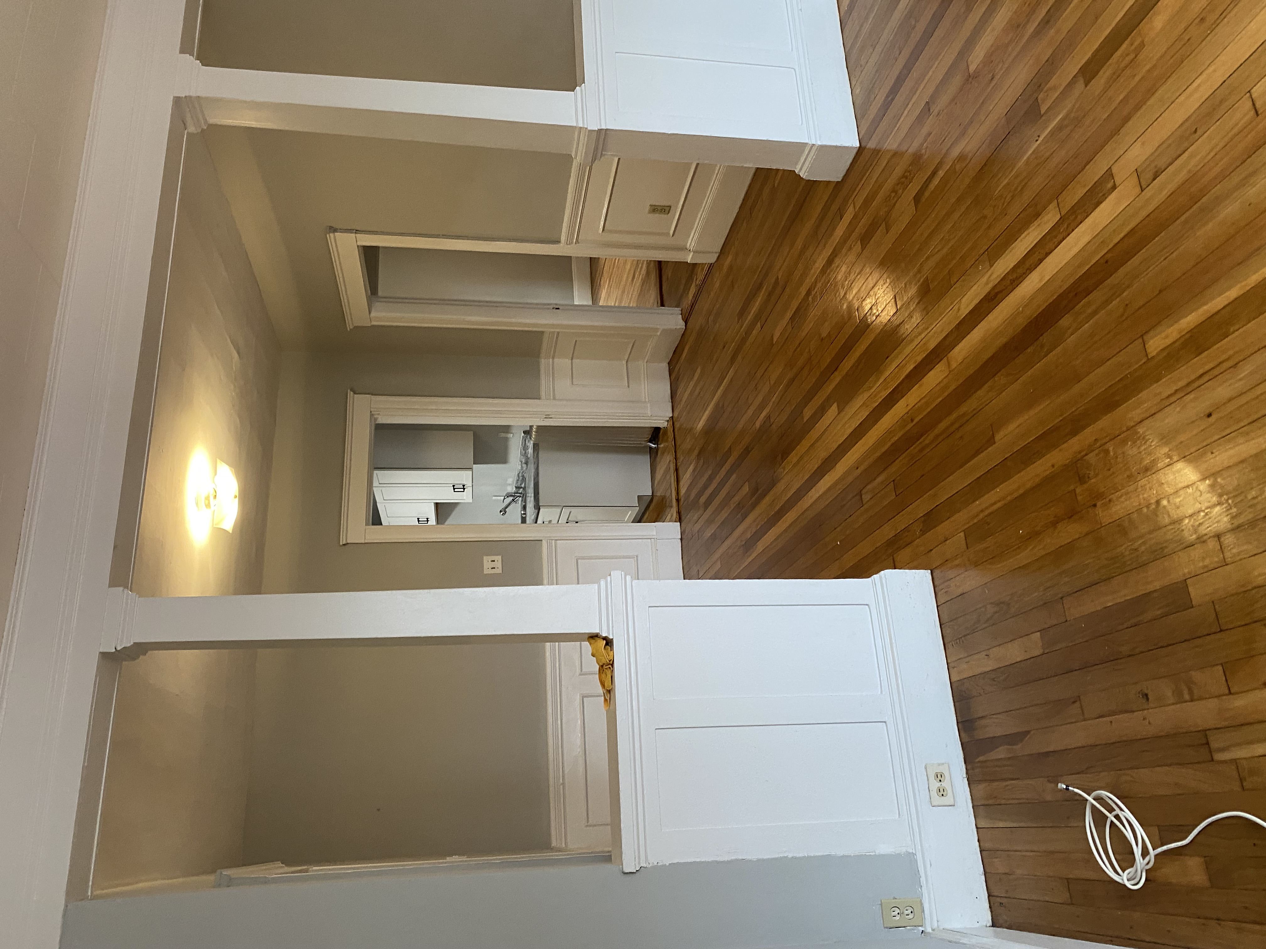 A white cabinet is open to reveal a mirror and a light switch.