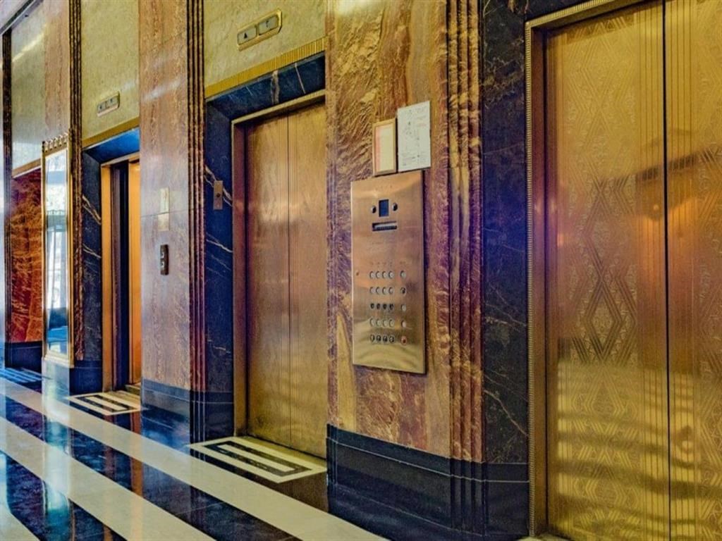 the elevators in the lobby of a building with gold doors