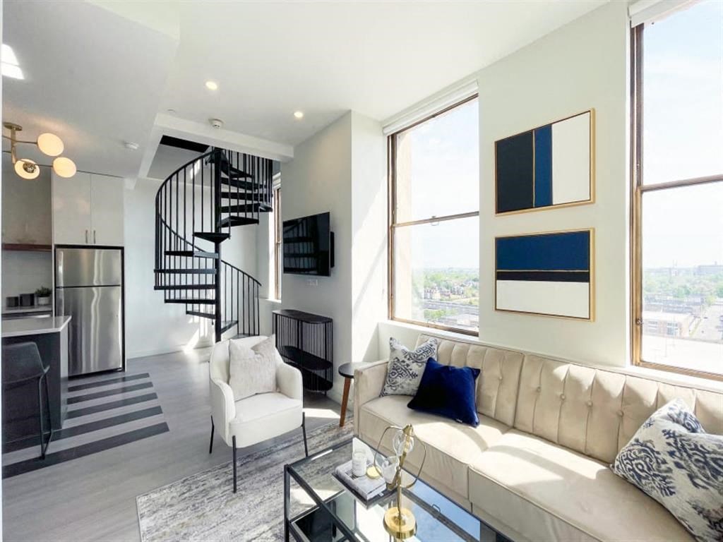 a living room with a couch and a spiral staircase