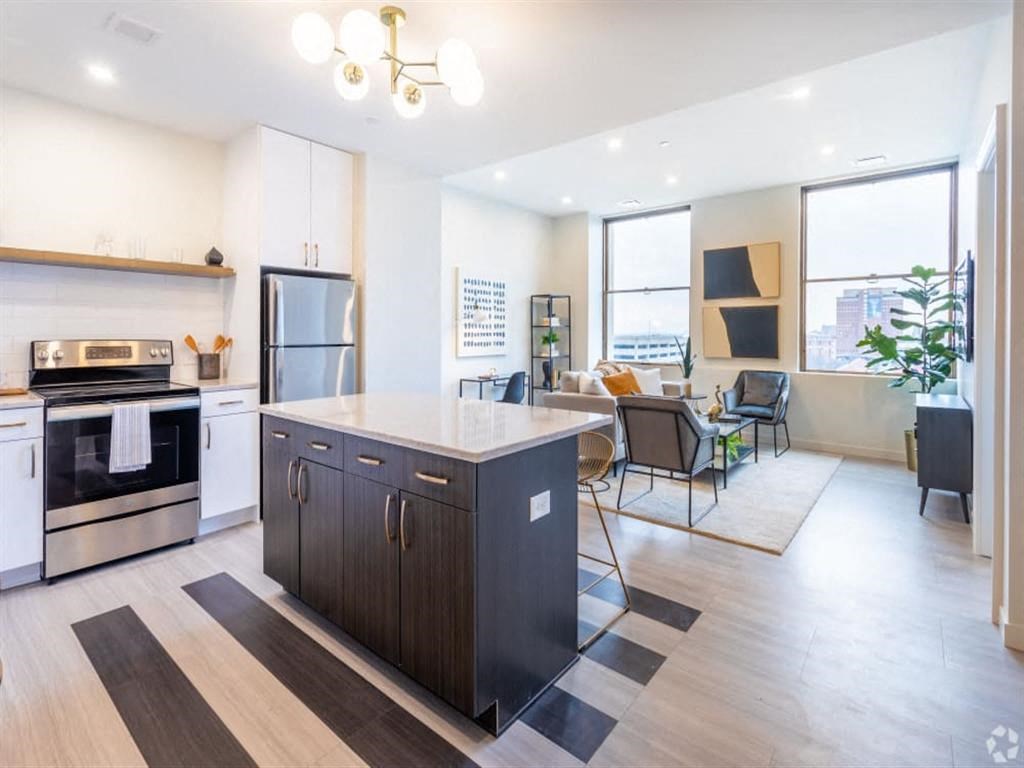 a kitchen and living room with a large island in the middle
