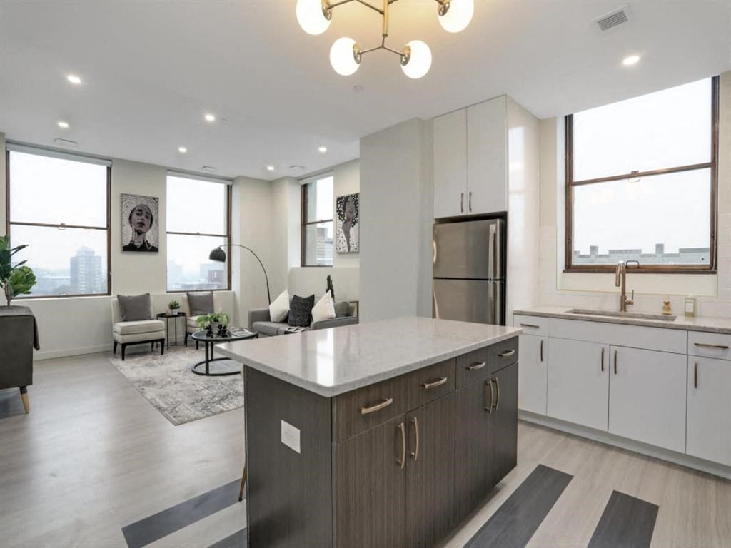 an open kitchen and living room with a large counter top