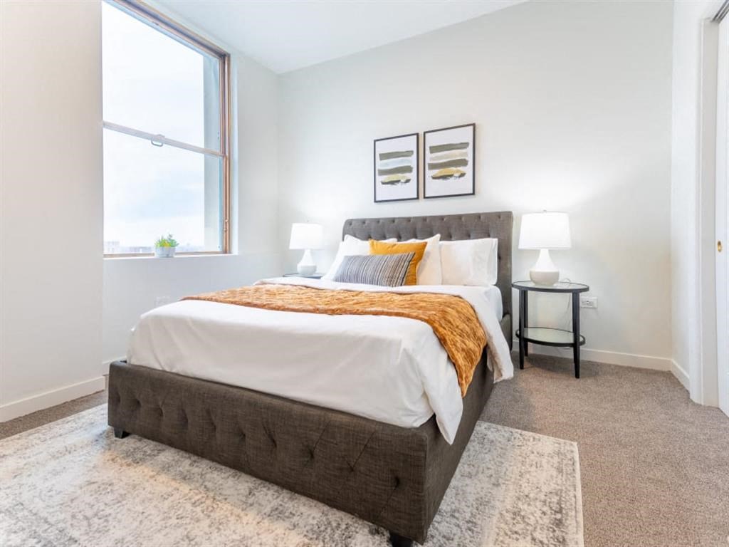 a bedroom with a bed and a large window