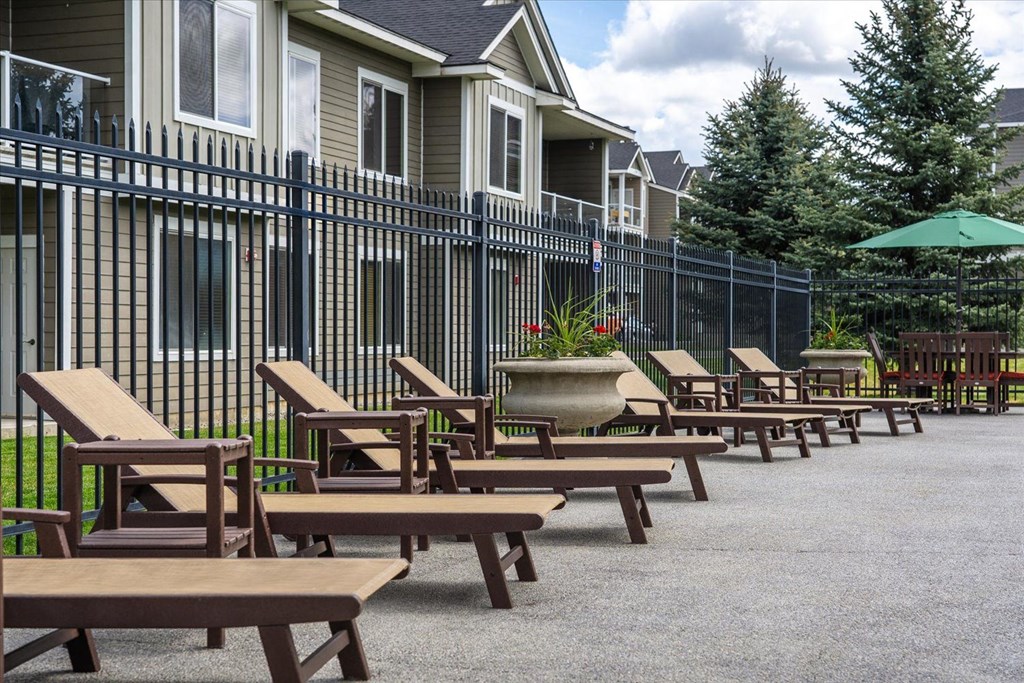 a row of wooden tables and chairs outside of a building