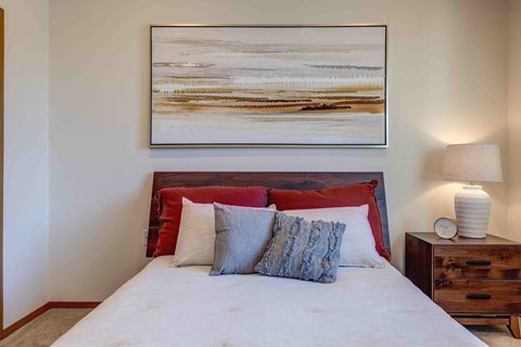 a bedroom with a bed and a nightstand with a lamp