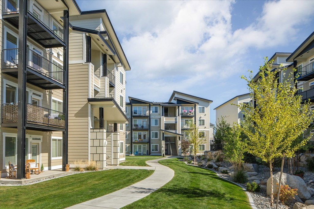 a sidewalk curves through a circle of modern apartment buildings