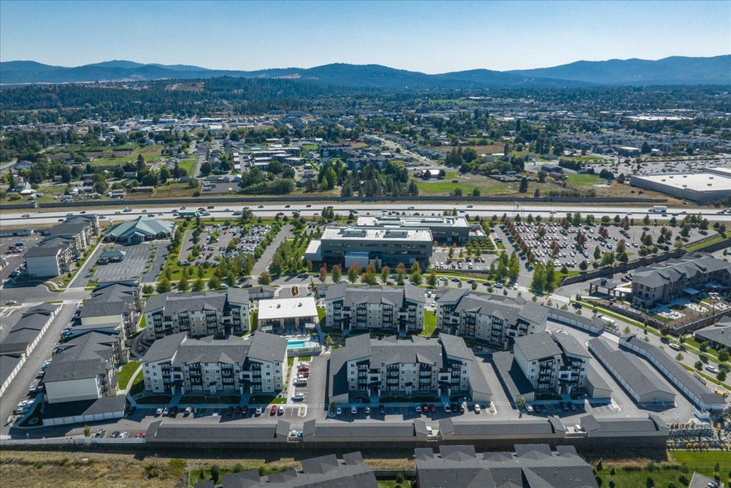 an aerial view of a suburb of a city with cars parked in a parking lot