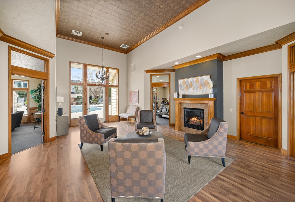 A living room with a fireplace and a checkered ottoman.