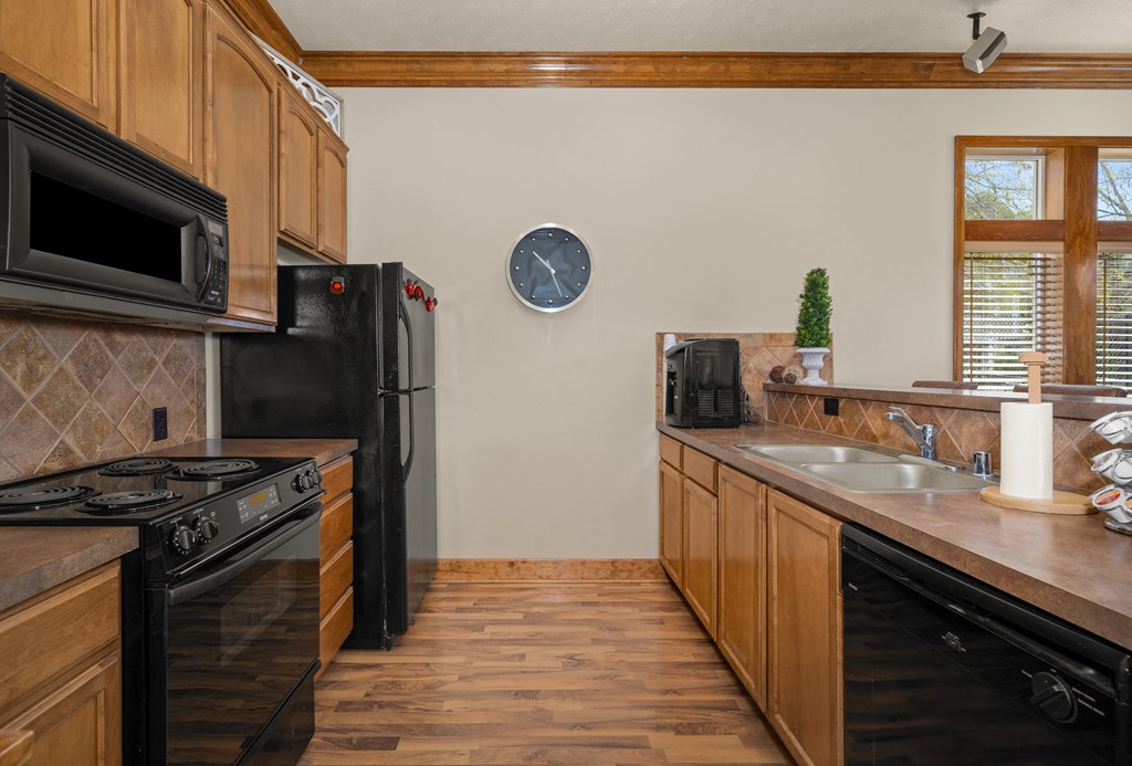 A kitchen with black appliances and wooden cabinets.