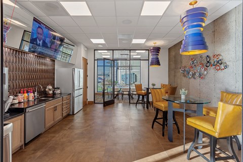 a dining area with a table and chairs and a television on the wall