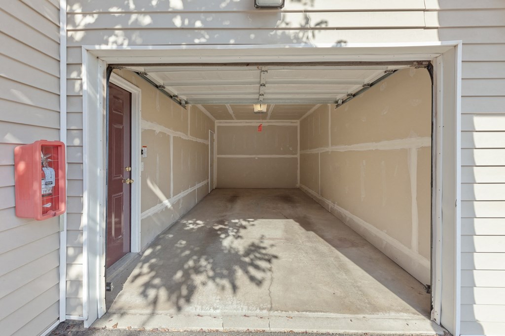 an empty garage with a red fire extinguisher on the side of the building