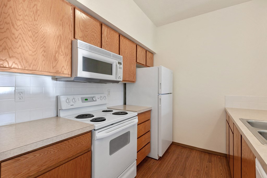 a kitchen with white appliances and wooden cabinets