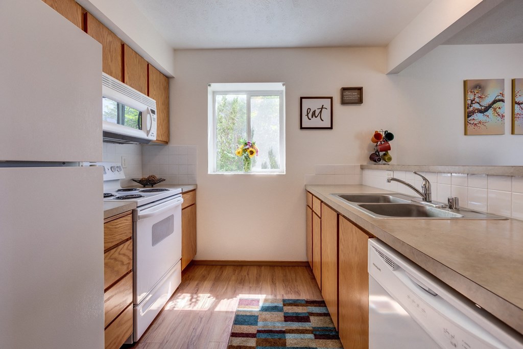 a kitchen with white appliances and wooden cabinets