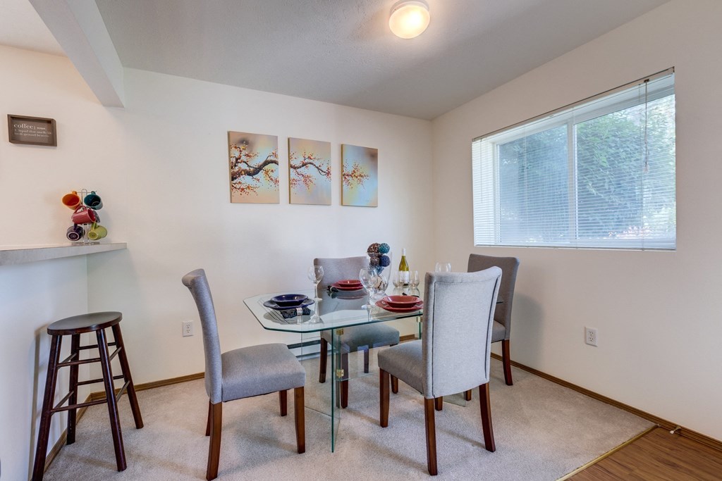a dining room with a glass table and chairs