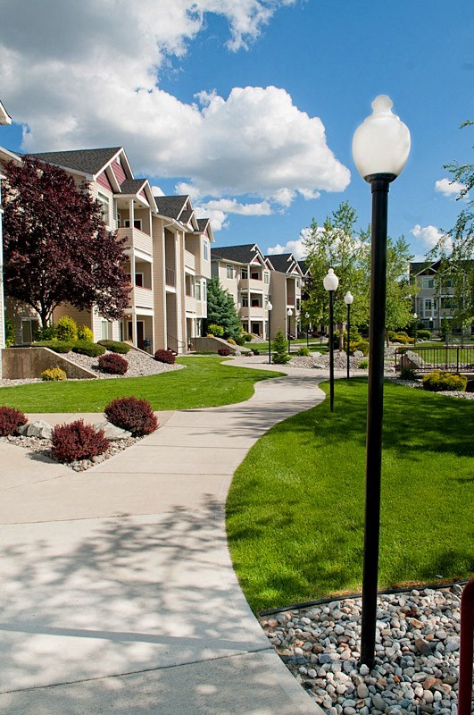 a walkway in front of an apartment complex