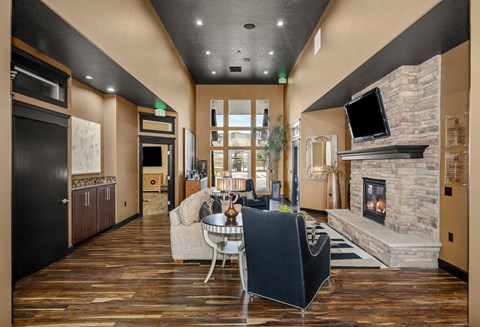 A modern living room with a stone fireplace and a television above it.