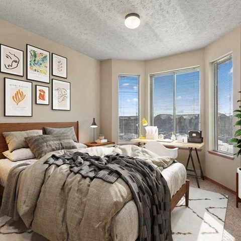 a bedroom with a bed and three windows