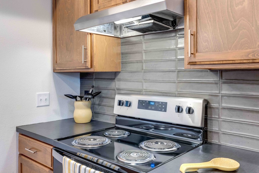 a kitchen with wood cabinets and a stove top oven