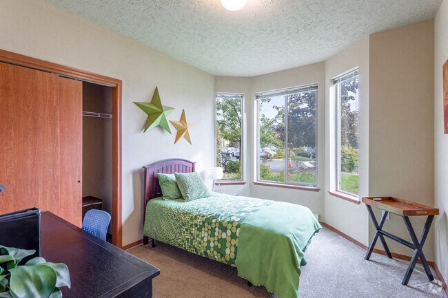 A bedroom with a bed and a desk