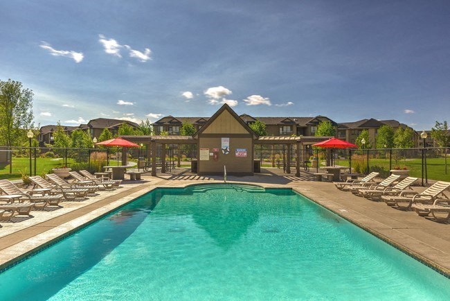 A resort style pool with chaise lounge chairs and umbrellas