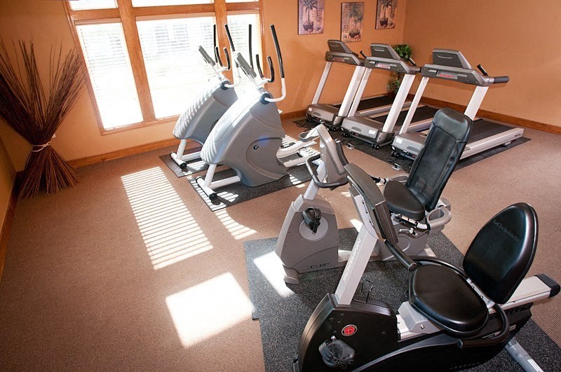 a room with a row of exercise bikes in front of a window