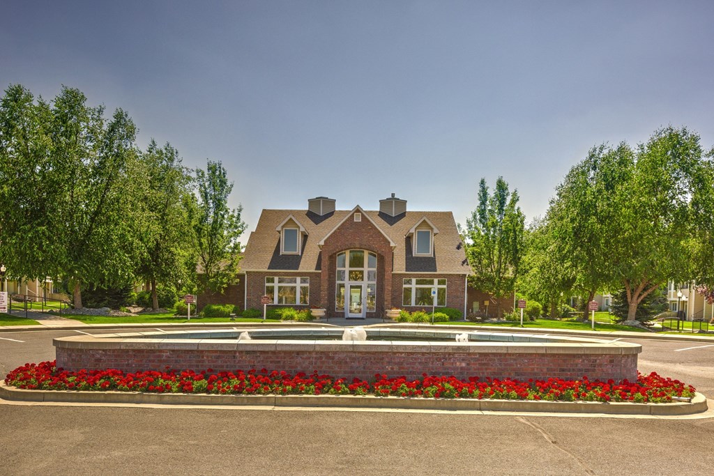 a large brick house with a fountain in front of it
