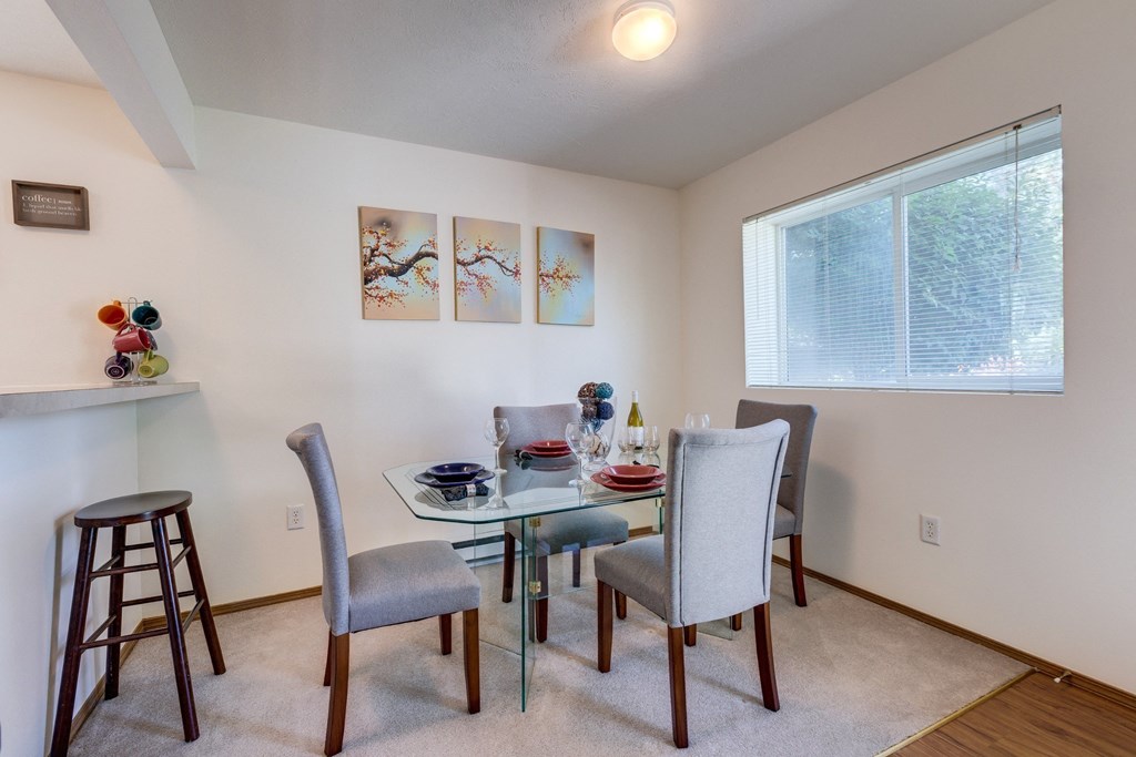 a dining room with a glass table and chairs