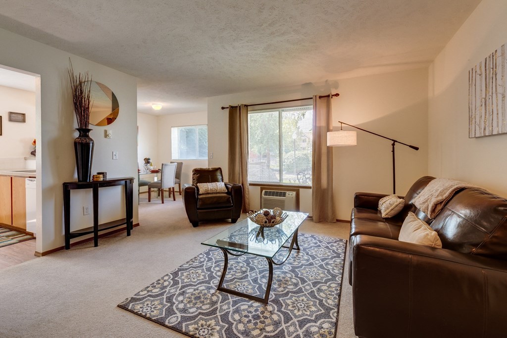 a living room with leather furniture and a glass coffee table