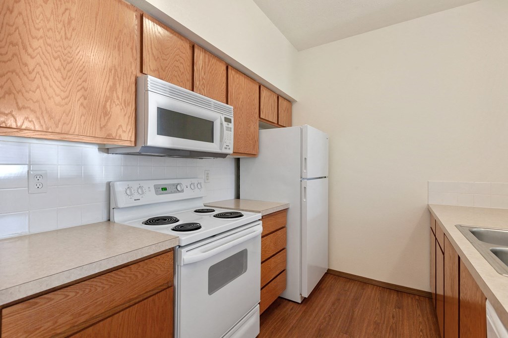 a kitchen with white appliances and wooden cabinets