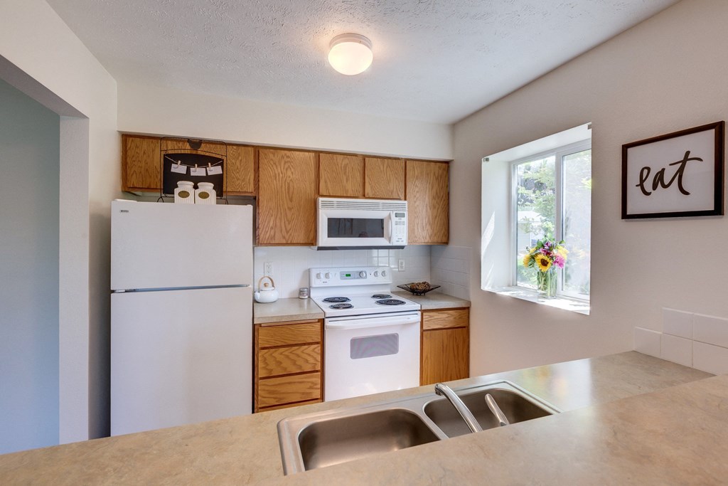 a kitchen with white appliances and wooden cabinets