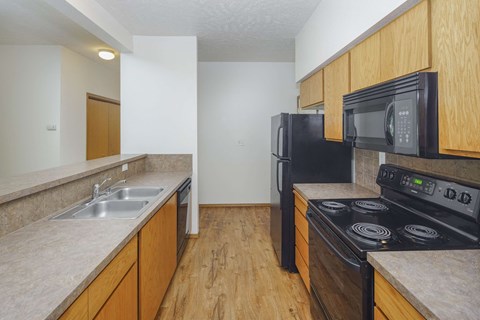 a kitchen with black appliances and wooden cabinets