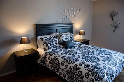 a bedroom with a bed and two lamps