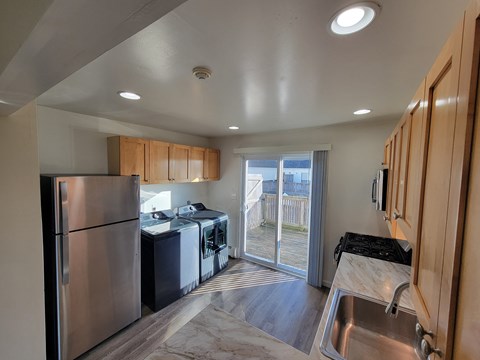 A kitchen with a stainless steel refrigerator and a sink.