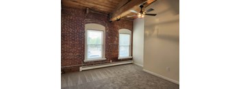 A room with a brick wall and a ceiling fan.