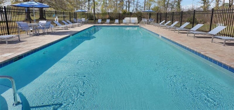 a large swimming pool with chairs and umbrellas