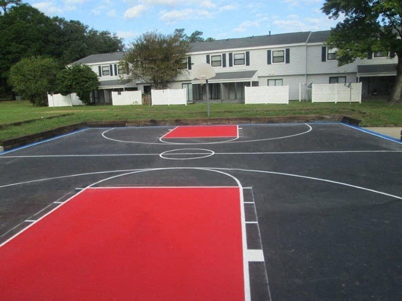 a black and red basketball court in front of a building