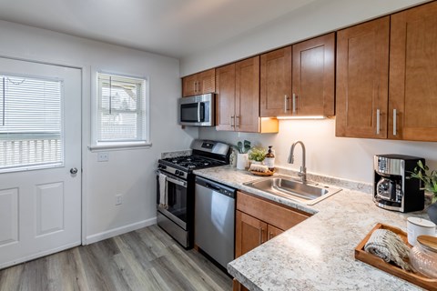 A kitchen with a sink, stove, and microwave.