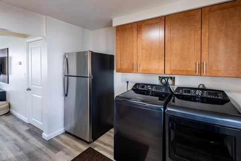 A black refrigerator and oven in a kitchen with wooden cabinets.