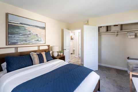 A bedroom with a large bed and a painting on the wall.