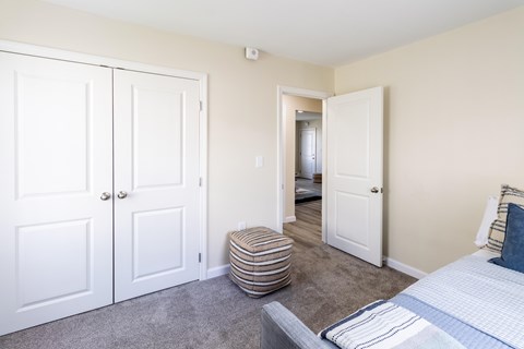 A bedroom with a bed, a dresser, and a wardrobe.